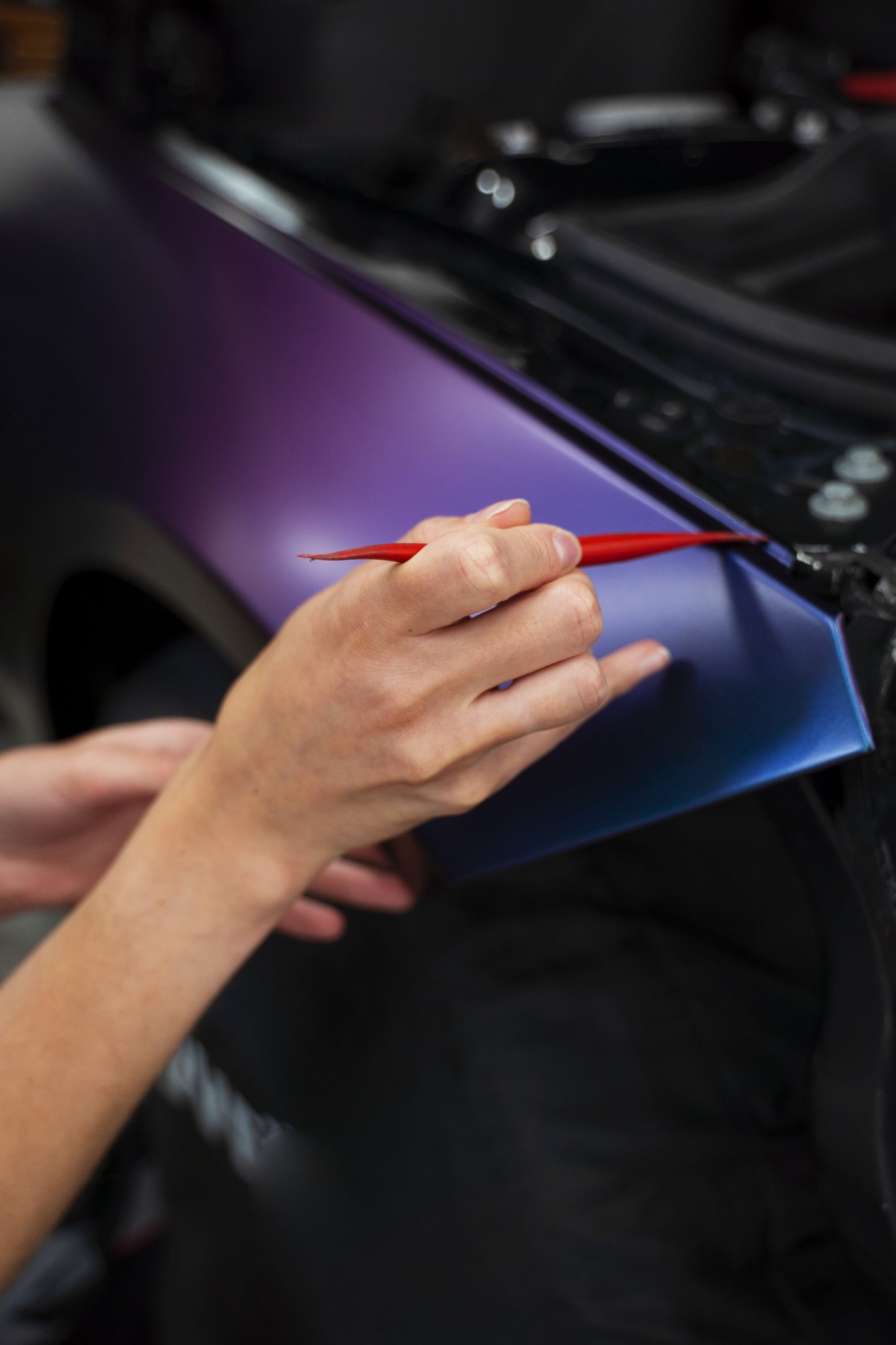 Technician's hand applying finishing touches on window tint at Diamond Window Tinting Chicago