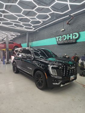 Black GMC Yukon Denali with full ceramic window tint inside Ghost Industries studio after service by Diamond Window Tinting Chicago